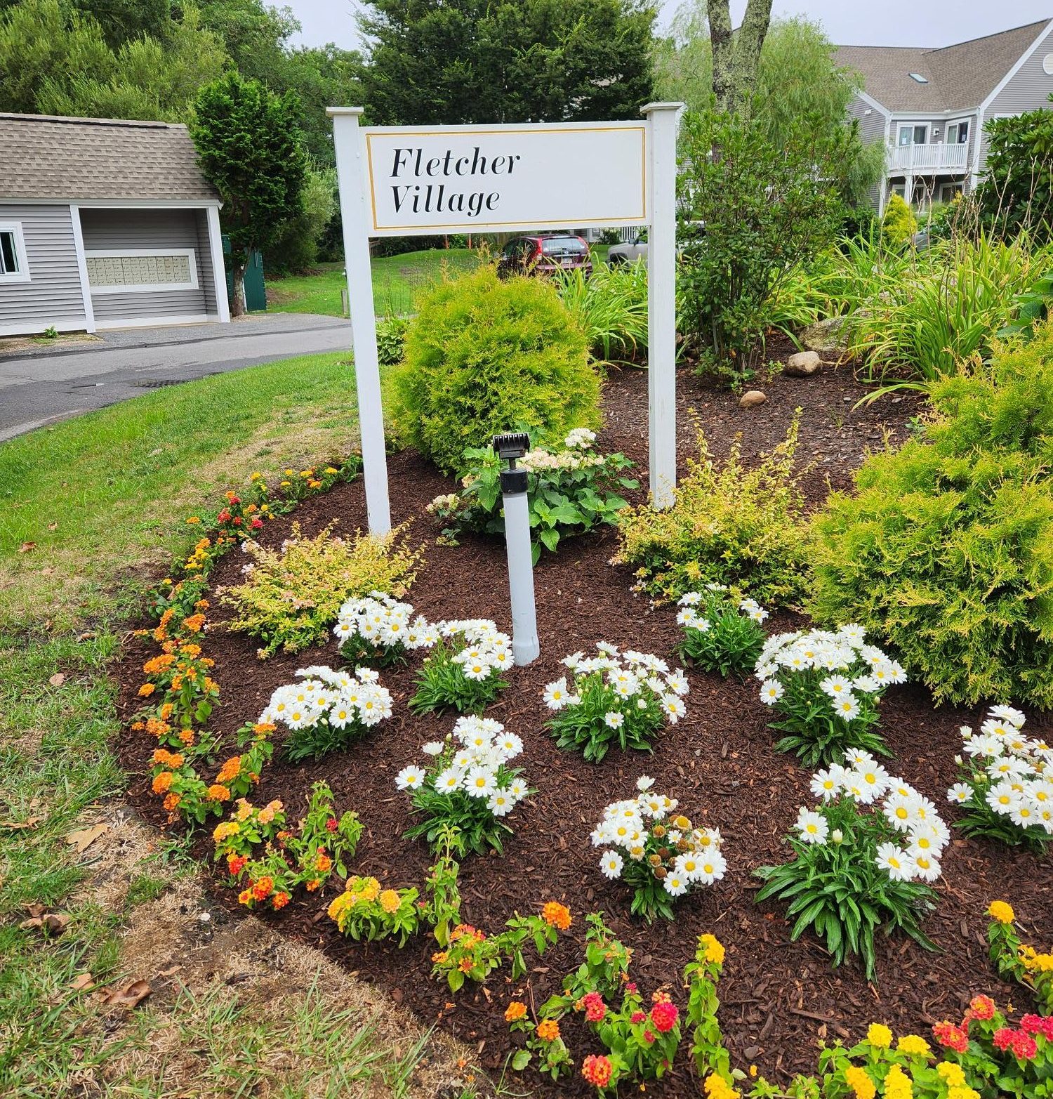 Fletcher Village sign among beautiful landscaping and houses in the background.
