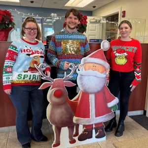 Bank employees wearing ugly Christmas sweaters for a contest.
