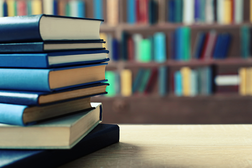 A stack of books on a table in a library.