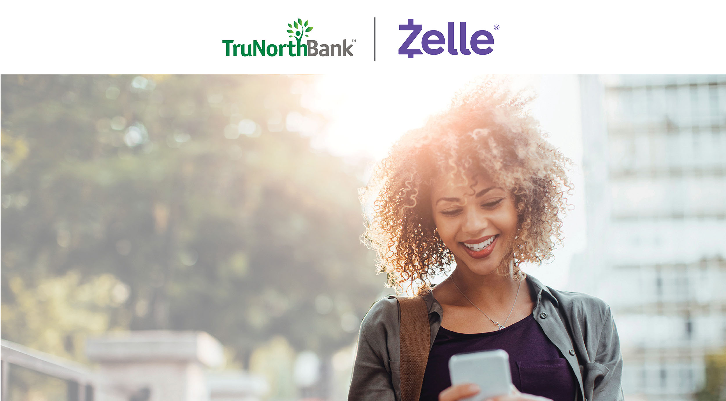 Smiling woman standing outside and interacting with her phone