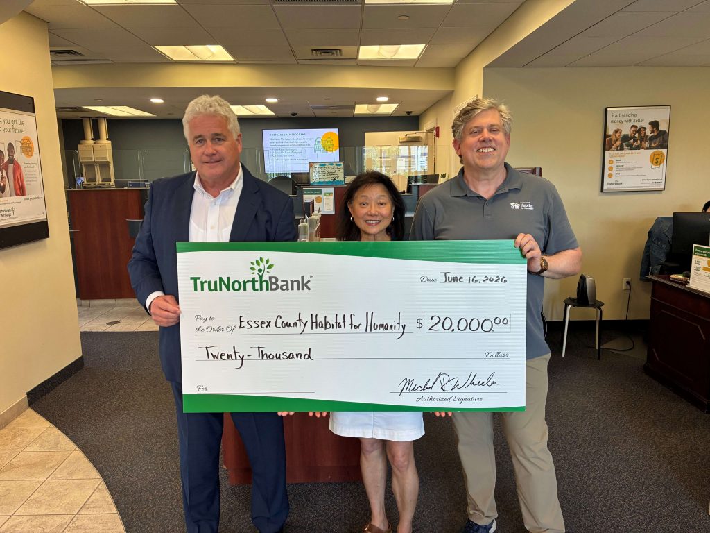 A group photo of a donation to Essex County Habitat for Humanity. 