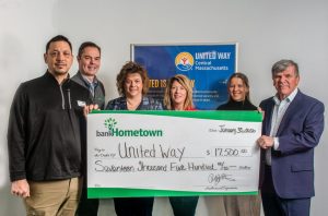 A group holds a big check donation for United Way.