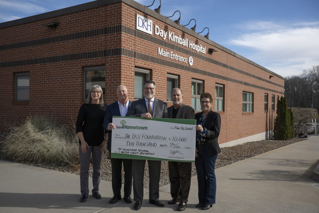 A group of people holding a donation check for Day Kimball Hospital Foundation.